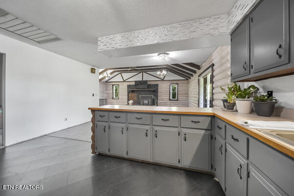 441 Morton Rd, Lafollette, TN 37766 - kitchen featuring gray cabinetry, a peninsula, light countertops, vaulted ceiling, and open floor plan