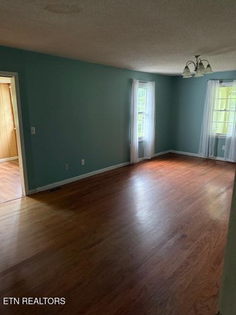 547 Knob Rd, Vonore, TN 37885 - spare room with wood finished floors, a chandelier, and baseboards