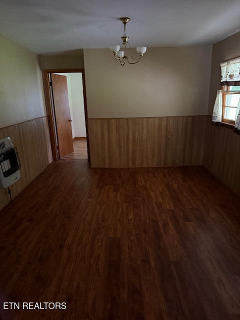 547 Knob Rd, Vonore, TN 37885 - empty room featuring wainscoting, heating unit, dark wood-style flooring, a chandelier, and wood walls
