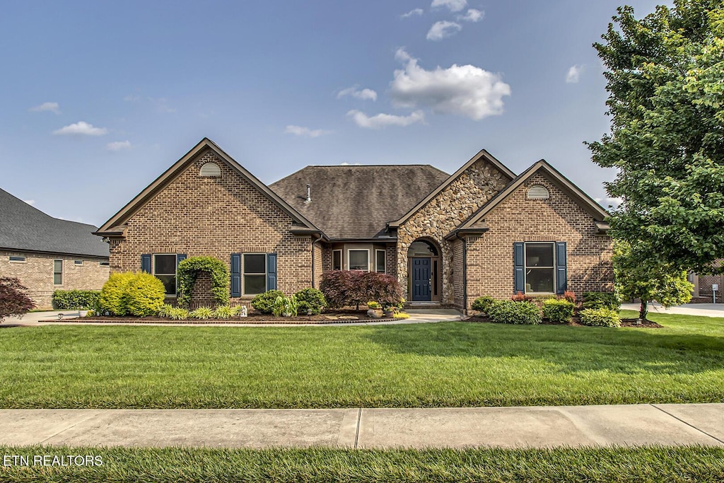 156 Millstone Ln, Lenoir City, TN 37772 - view of front of home featuring brick siding, a front lawn, and a shingled roof