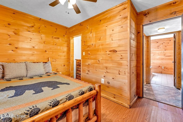 1513 Tyler Way, Sevierville, TN 37876 - bedroom featuring wood walls, wood finished floors, ceiling fan, and ensuite bath