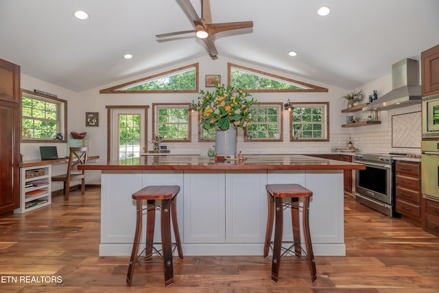 1932 Duncan Rd, Knoxville, TN 37919 - kitchen with stainless steel appliances, wall chimney range hood, lofted ceiling, a breakfast bar, and decorative backsplash