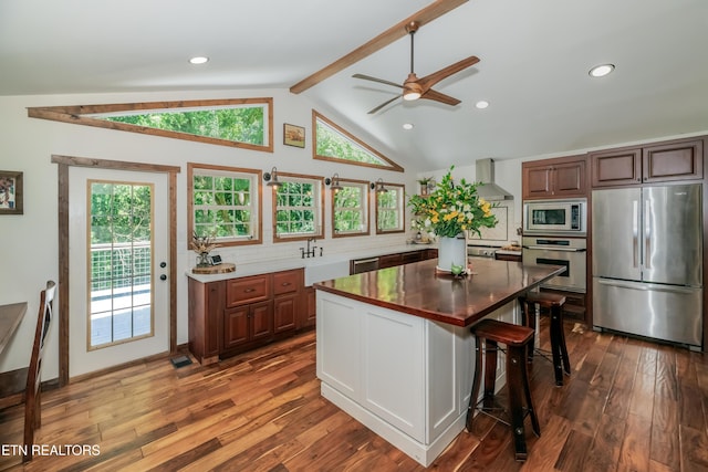 1932 Duncan Rd, Knoxville, TN 37919 - kitchen with appliances with stainless steel finishes, wall chimney range hood, a ceiling fan, backsplash, and dark wood-style flooring