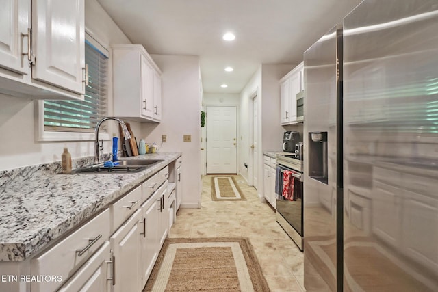 3021 Shawnee Rd, Crossville, TN 38572 - kitchen featuring stainless steel appliances, white cabinetry, a sink, recessed lighting, and light stone countertops