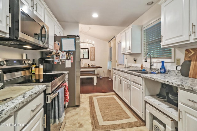 3021 Shawnee Rd, Crossville, TN 38572 - kitchen featuring stainless steel appliances, a sink, white cabinets, lofted ceiling, and a chandelier