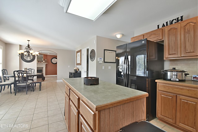 5821 Matalin Ln, Knoxville, TN 37918 - kitchen featuring black fridge, light tile patterned flooring, arched walkways, and a chandelier