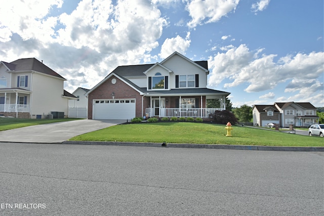 5821 Matalin Ln, Knoxville, TN 37918 - view of front of house featuring covered porch, brick siding, a front yard, concrete driveway, and a garage