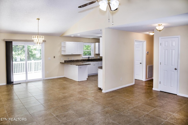 247 Lakeview Dr, Crossville, TN 38558 - kitchen with dark countertops, white cabinetry, baseboards, a chandelier, and a ceiling fan