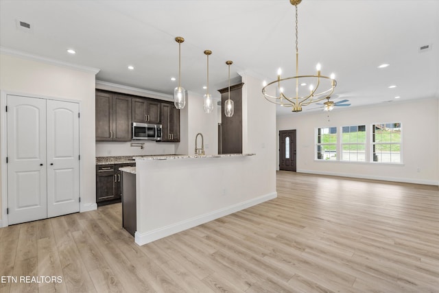 1287 Lori Ellen Ct, Sevierville, TN 37876 - kitchen with stainless steel microwave, ornamental molding, dark brown cabinetry, baseboards, and a chandelier