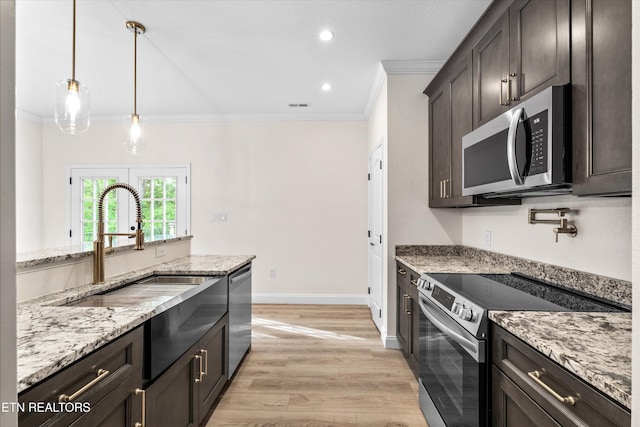 1287 Lori Ellen Ct, Sevierville, TN 37876 - kitchen with appliances with stainless steel finishes, crown molding, light wood finished floors, light stone countertops, and dark brown cabinetry