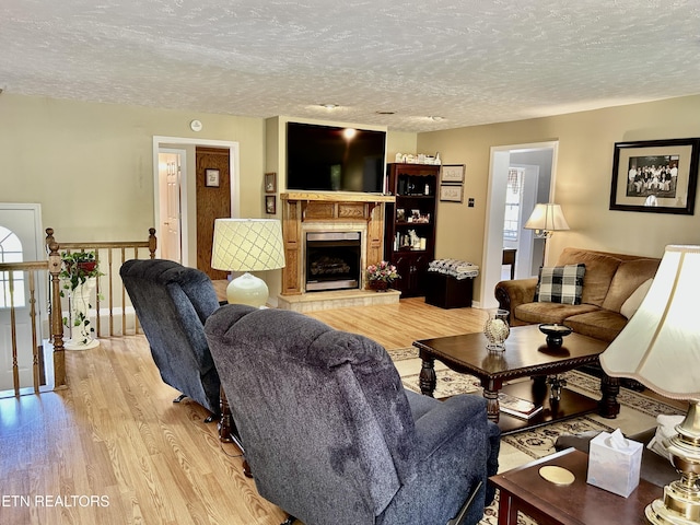 762 Commanche Dr, Jefferson City, TN 37760 - living room featuring light wood-style flooring, a textured ceiling, and a fireplace with raised hearth