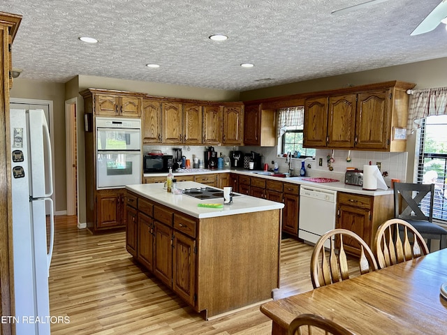 762 Commanche Dr, Jefferson City, TN 37760 - kitchen featuring white appliances, a sink, light wood-style flooring, a kitchen island with sink, and light countertops