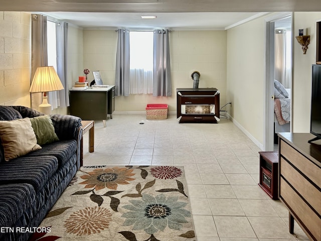 762 Commanche Dr, Jefferson City, TN 37760 - living room featuring a wood stove, ornamental molding, light tile patterned flooring, concrete block wall, and baseboards