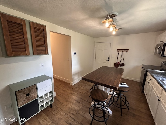 724 Montvue Ave, Morristown, TN 37813 - kitchen with stainless steel microwave, electric stove, dark wood finished floors, white cabinetry, and dark countertops