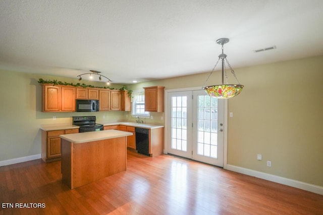 1117 Worthington Blvd, Maryville, TN 37801 - kitchen with black appliances, light countertops, a center island, light wood-style flooring, and decorative light fixtures