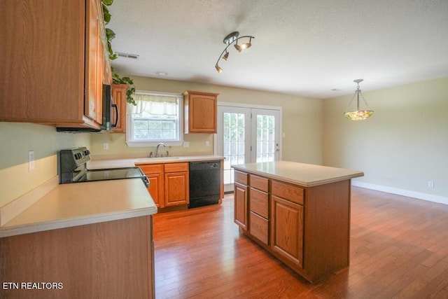 1117 Worthington Blvd, Maryville, TN 37801 - kitchen featuring black appliances, light countertops, light wood-type flooring, a kitchen island, and pendant lighting