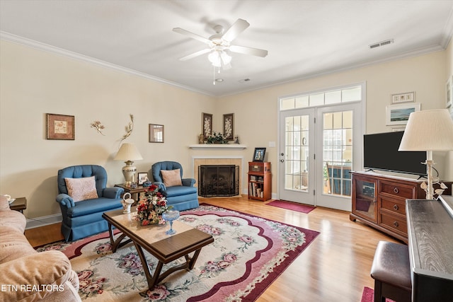 7830 Thomas Henry Way, Knoxville, TN 37938 - living room featuring ornamental molding, light wood-style floors, a ceiling fan, and a tile fireplace