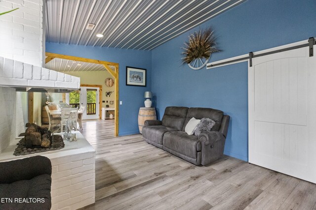 2115 Riverview Dr, Dandridge, TN 37725 - living room featuring a barn door, wood finished floors, lofted ceiling, and french doors