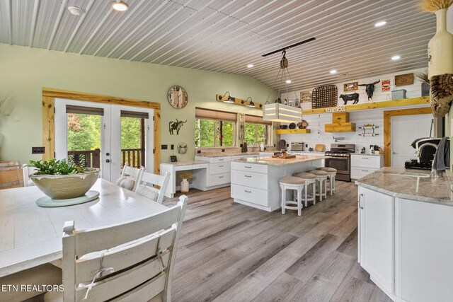 2115 Riverview Dr, Dandridge, TN 37725 - kitchen featuring stainless steel gas range oven, open shelves, white cabinetry, recessed lighting, and light wood finished floors