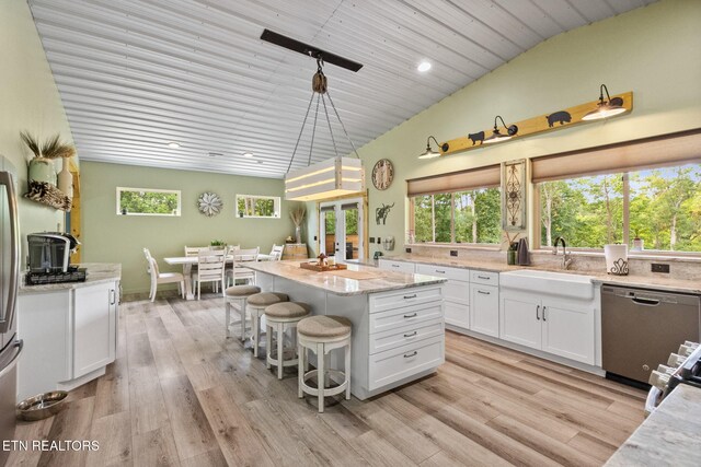 2115 Riverview Dr, Dandridge, TN 37725 - kitchen with stainless steel dishwasher, a sink, lofted ceiling, white cabinets, and a center island