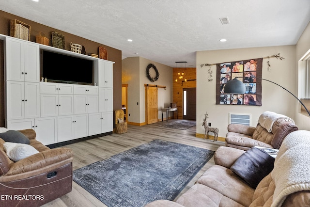 2115 Riverview Dr, Dandridge, TN 37725 - living room with recessed lighting, light wood-style flooring, a barn door, baseboards, and a textured ceiling