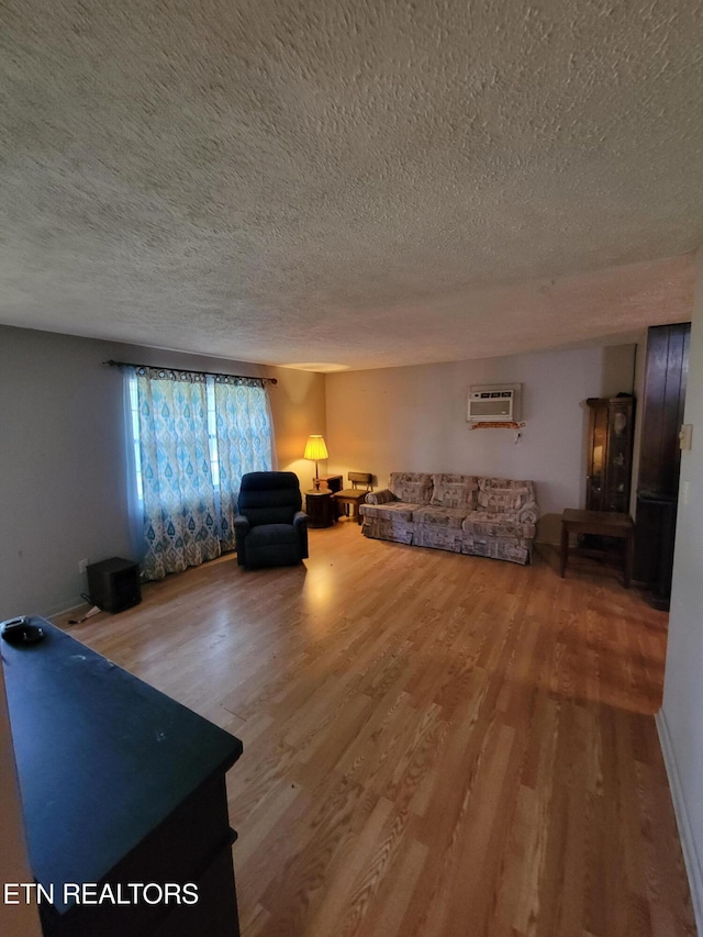1403 Skyline Dr, New Market, TN 37820 - living room featuring a textured ceiling, wood finished floors, and a wall unit AC