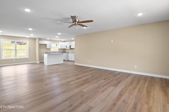294 Mountain Perkins Ln, Jacksboro, TN 37757 - unfurnished living room featuring light wood-style flooring, baseboards, recessed lighting, ceiling fan, and a sink