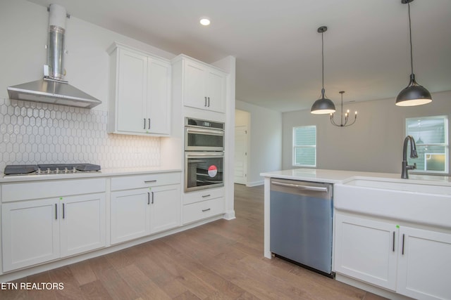 349 Ivey Farms Ln, Farragut, TN 37934 - kitchen featuring appliances with stainless steel finishes, exhaust hood, light countertops, light wood-style flooring, and white cabinetry
