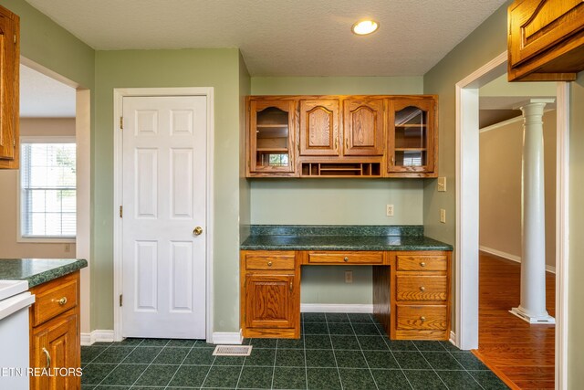 178 Scenic Hill Ln, Lenoir City, TN 37771 - unfurnished office featuring built in desk, baseboards, dark tile patterned flooring, and ornate columns