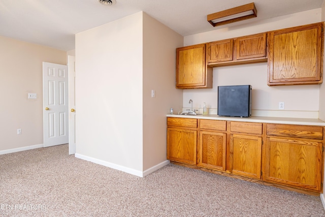 178 Scenic Hill Ln, Lenoir City, TN 37771 - kitchen with brown cabinetry, light countertops, light carpet, and baseboards