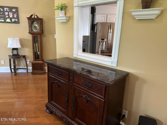 133 Coolidge Rd, Lafollette, TN 37766 - detailed view of light wood-style floors, stainless steel fridge, baseboards, white cabinets, and dark stone countertops