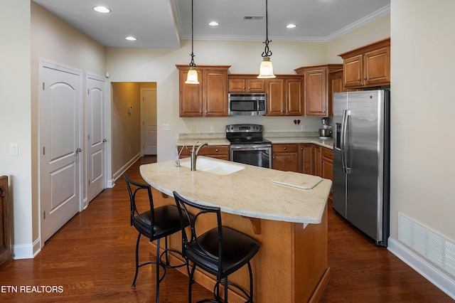 4921 Willow Bluff Cir, Knoxville, TN 37914 - kitchen featuring appliances with stainless steel finishes, a sink, brown cabinets, an island with sink, and a breakfast bar area