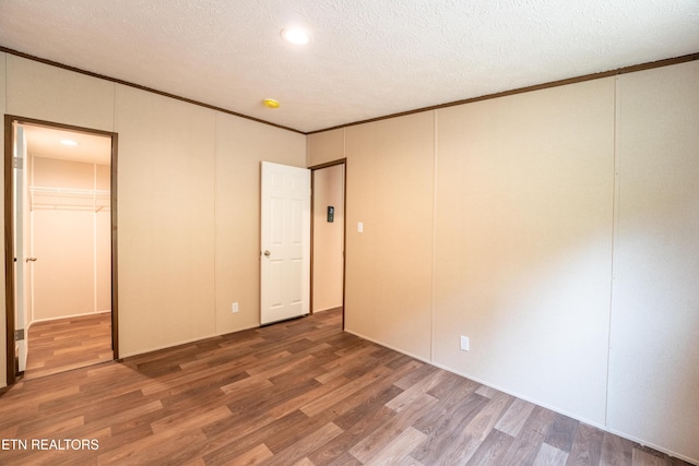 1587 Sweetwater Rd, Philadelphia, TN 37846 - unfurnished bedroom featuring wood finished floors, crown molding, a decorative wall, a closet, and a textured ceiling
