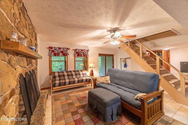258 Marina Ln, Lafollette, TN 37766 - tiled living room with a textured ceiling, a ceiling fan, stairs, and a fireplace