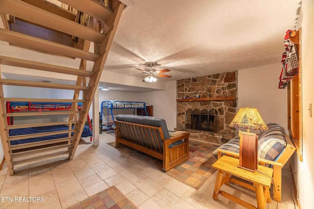 258 Marina Ln, Lafollette, TN 37766 - bedroom with a textured ceiling, a stone fireplace, light tile patterned floors, and a ceiling fan
