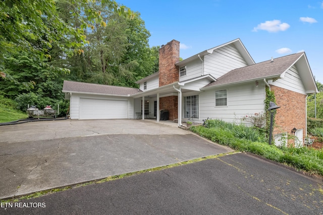 10628 Sandpiper Ln, Knoxville, TN 37922 - traditional-style home featuring a chimney, an attached garage, asphalt driveway, brick siding, and a porch