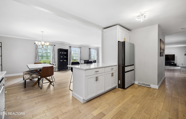 10628 Sandpiper Ln, Knoxville, TN 37922 - kitchen featuring freestanding refrigerator, light wood finished floors, white cabinetry, a chandelier, and ornamental molding