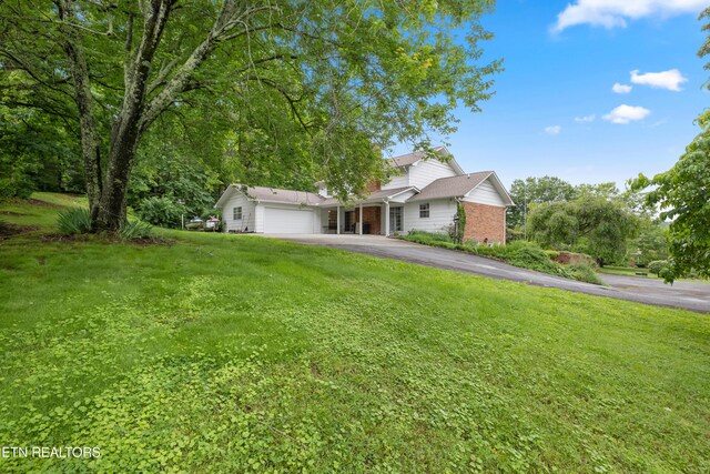 10628 Sandpiper Ln, Knoxville, TN 37922 - view of front of home featuring asphalt driveway, a garage, a front lawn, and brick siding