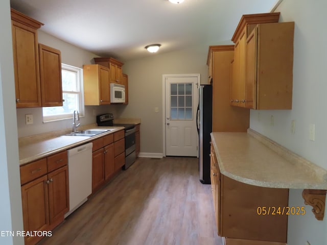5820 Rockwood Ln, Knoxville, TN 37921 - kitchen featuring appliances with stainless steel finishes, a sink, light wood-style floors, light countertops, and brown cabinets