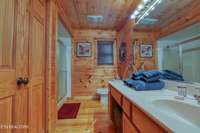1127 Oak Ct, Gatlinburg, TN 37738 - bathroom with wooden walls, wood-type flooring, vanity, a shower stall, and toilet