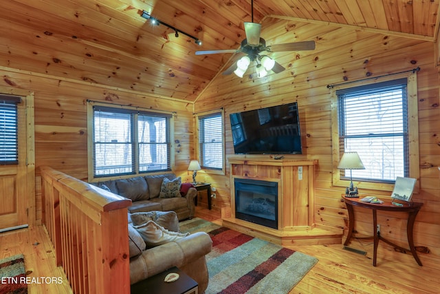 1127 Oak Ct, Gatlinburg, TN 37738 - living area featuring vaulted ceiling, wood ceiling, light wood-type flooring, track lighting, and wooden walls