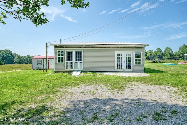 170 Bob Austin Rd, Crossville, TN 38571 - back of property with a trampoline, a lawn, french doors, a patio, and metal roof