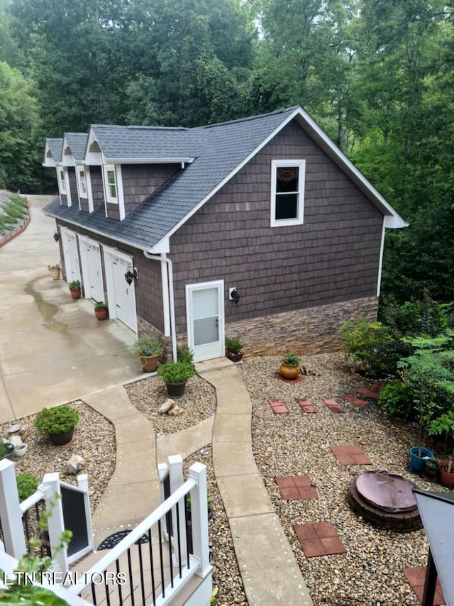 180 Silver Trl, New Tazewell, TN 37825 - view of side of property with a shingled roof, driveway, a view of trees, and a garage