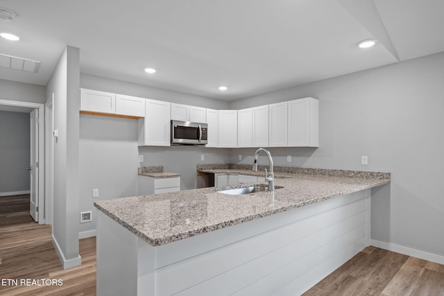 319 S Elmwood St, Knoxville, TN 37914 - kitchen featuring stainless steel microwave, a peninsula, a sink, baseboards, and recessed lighting