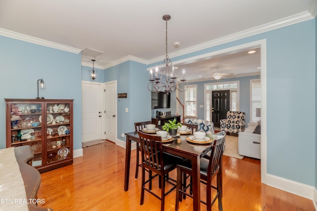 1101 Main St Unit 19, Loudon, TN 37774 - dining room with crown molding, light wood-style floors, a chandelier, ceiling fan, and a wood stove