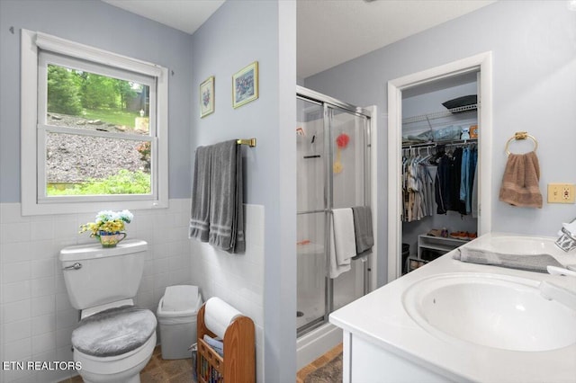 334 Little Buck Ln, Lafollette, TN 37766 - bathroom with a stall shower, toilet, a walk in closet, tile walls, and wainscoting