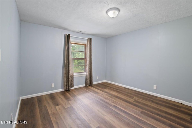 147 Cove Hollow Rd, Lafollette, TN 37766 - unfurnished room with a textured ceiling, dark wood finished floors, and baseboards