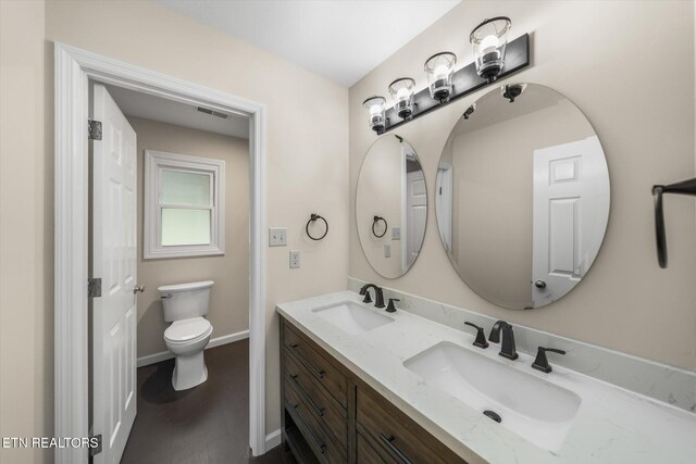 2819 Dee Peppers Dr, Knoxville, TN 37931 - bathroom featuring double vanity, toilet, baseboards, and wood finished floors