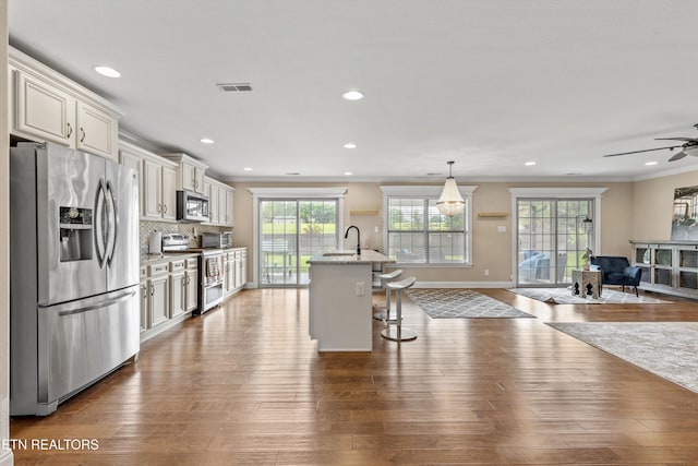 1017 Brighton Dr, Alcoa, TN 37701 - kitchen featuring appliances with stainless steel finishes, ornamental molding, ceiling fan, open floor plan, and a kitchen bar