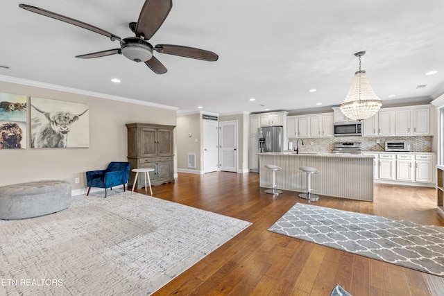 1017 Brighton Dr, Alcoa, TN 37701 - living room featuring ornamental molding, a chandelier, a ceiling fan, dark wood-style floors, and recessed lighting